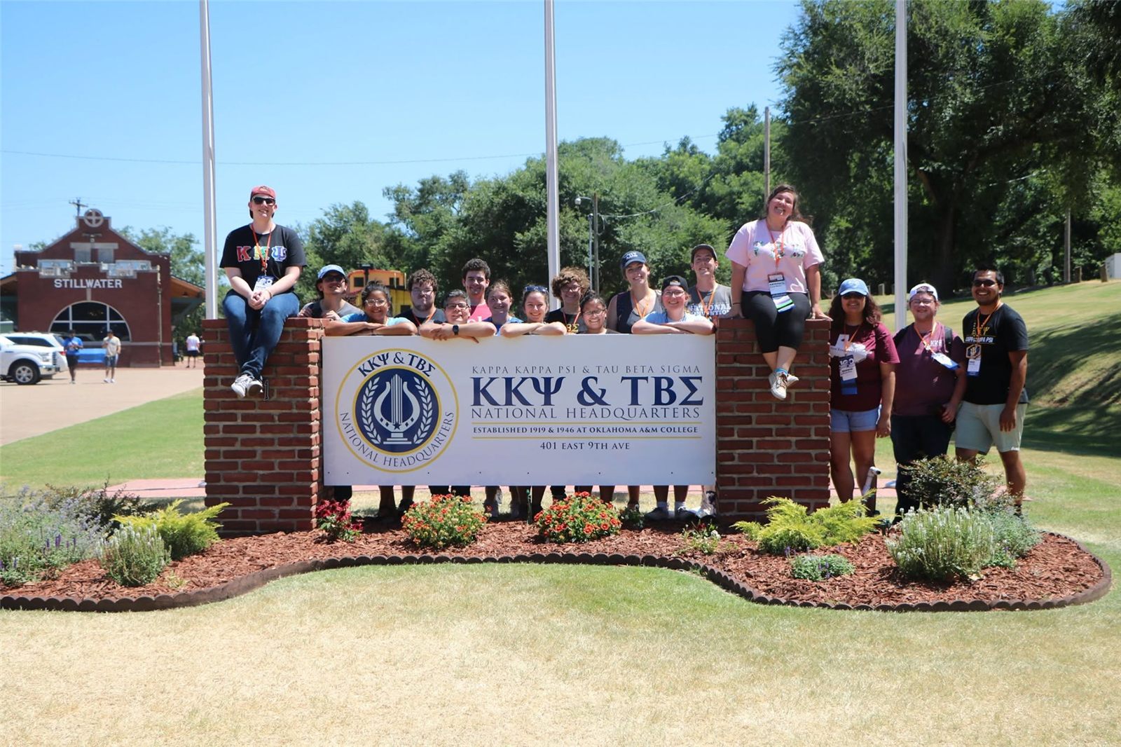 Brothers and sisters at the Kappa Kappa Psi and Tau Beta Sigma National Headquarters sign