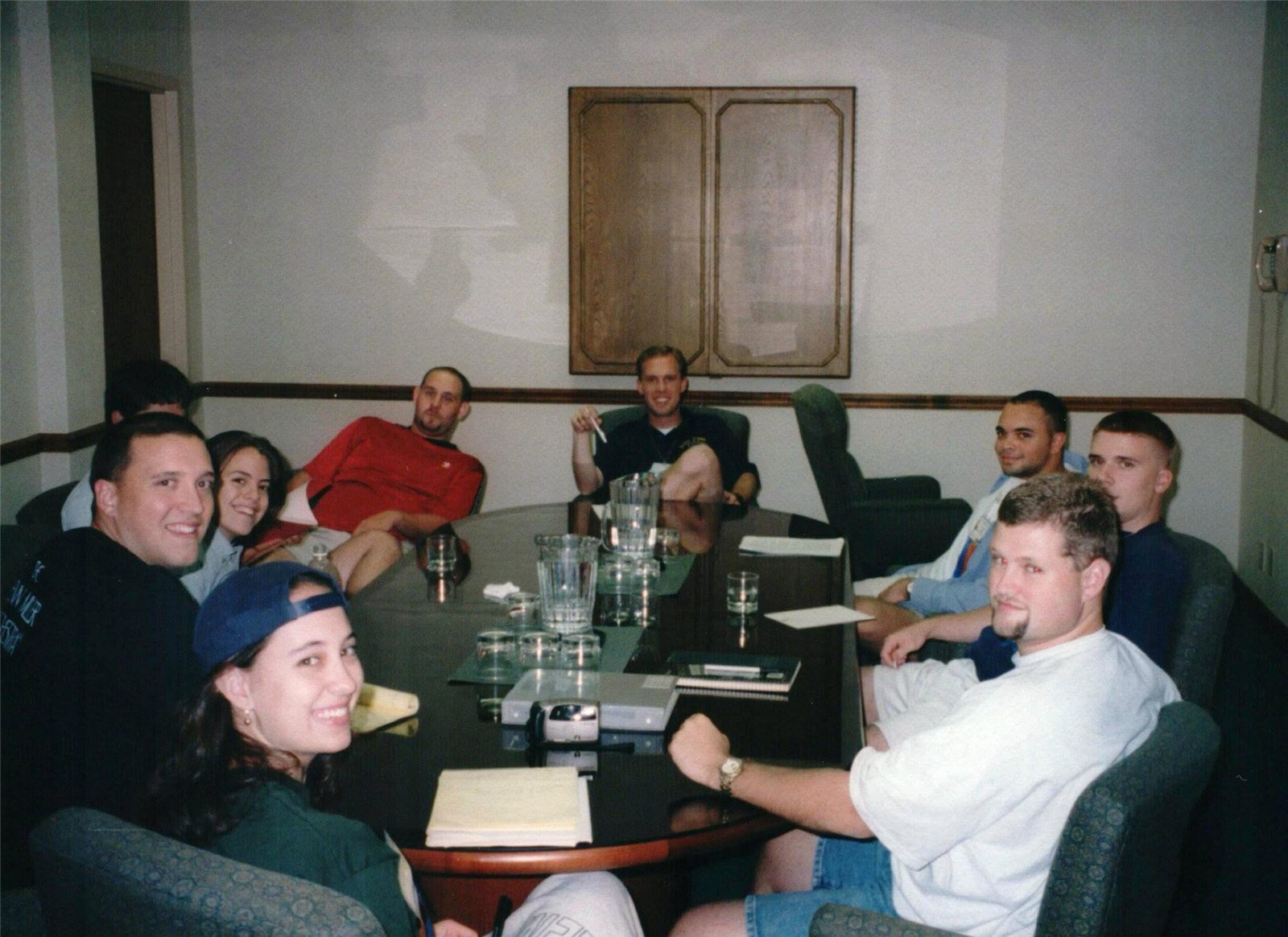 Brothers seated around a conference table, smiling at the camera